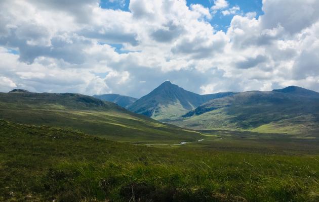 An image of hills with a cloudy and blue sky 