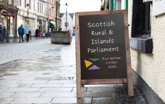 Placard on street in Fort William with text 'Scottish Rural and Islands Parliament'