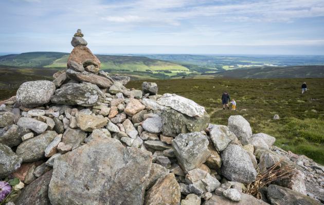 Image of cairn and family walking in the hills near Brechin