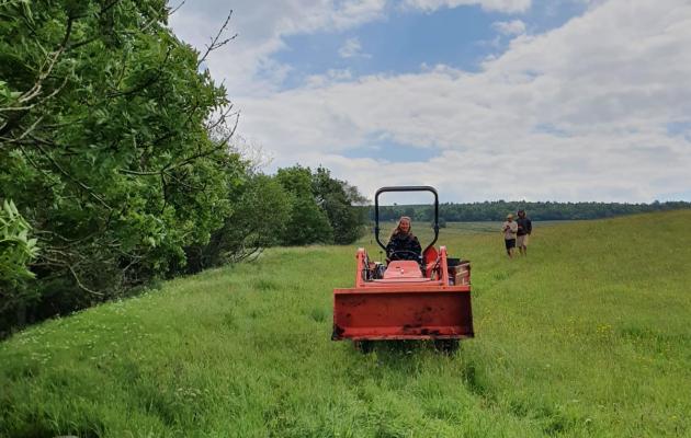 Image of people on a tractor in a green arable field