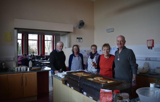 Image of people standing making pancakes