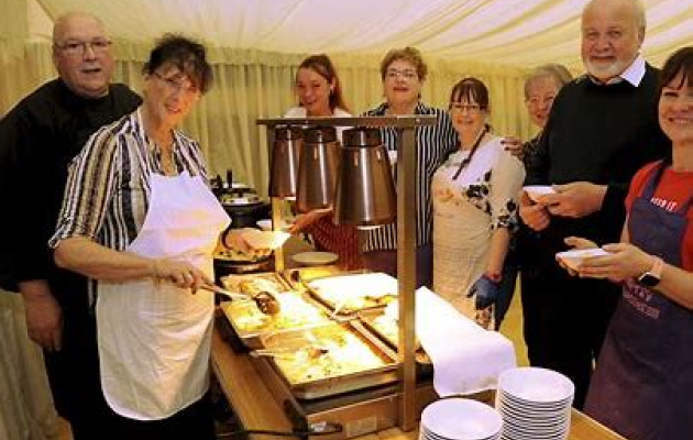 People standing together making food