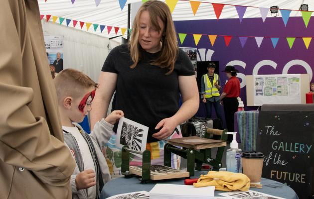 Boy looking at screen printing machine